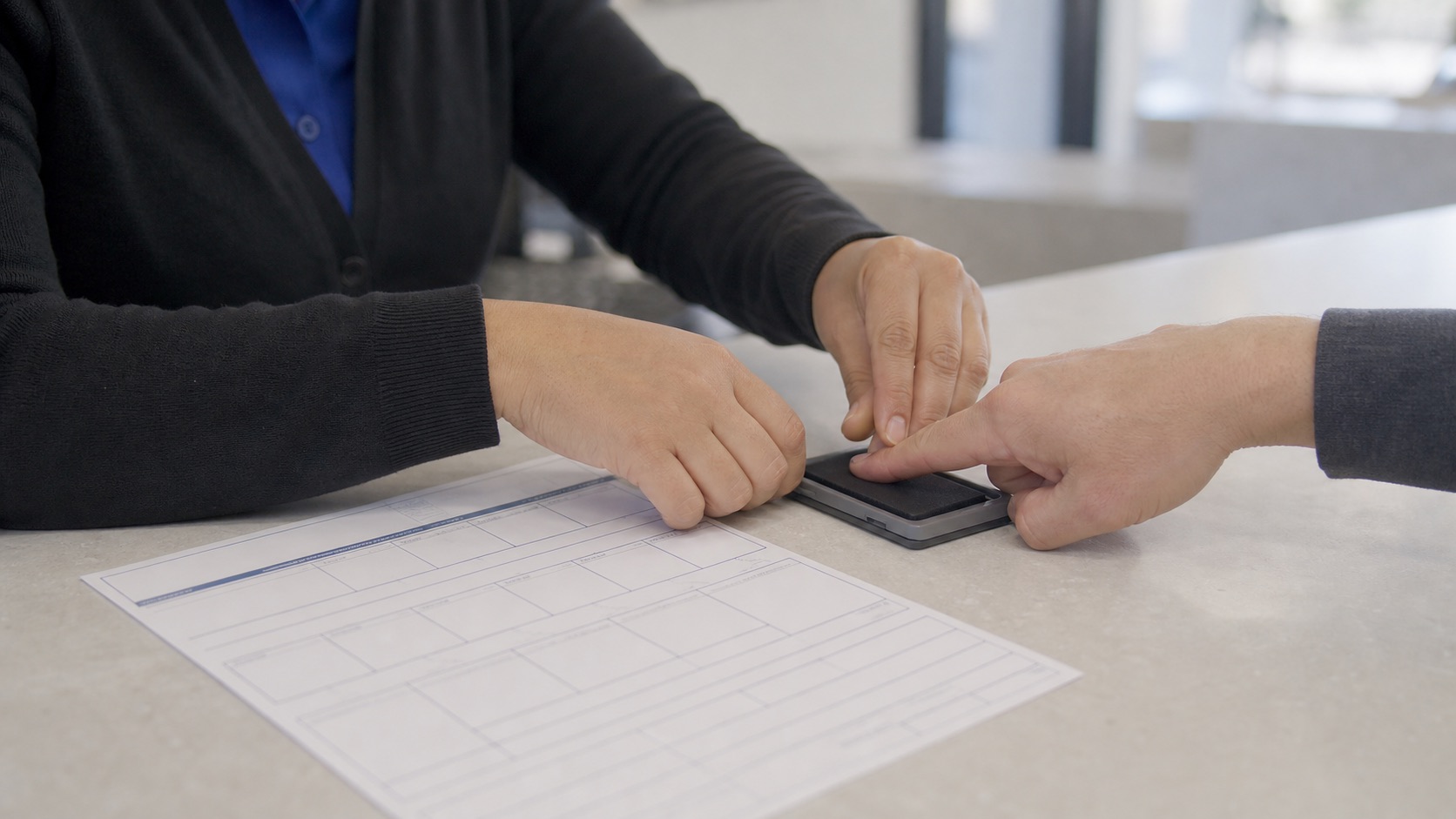 Technician completing an FD-258 ink fingerprint card in Mountain View
